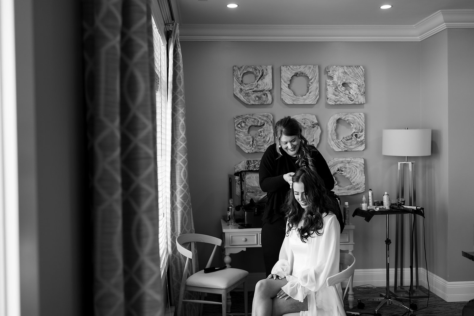 Black and white photo of a bride getting her hair done by Face by Nertila