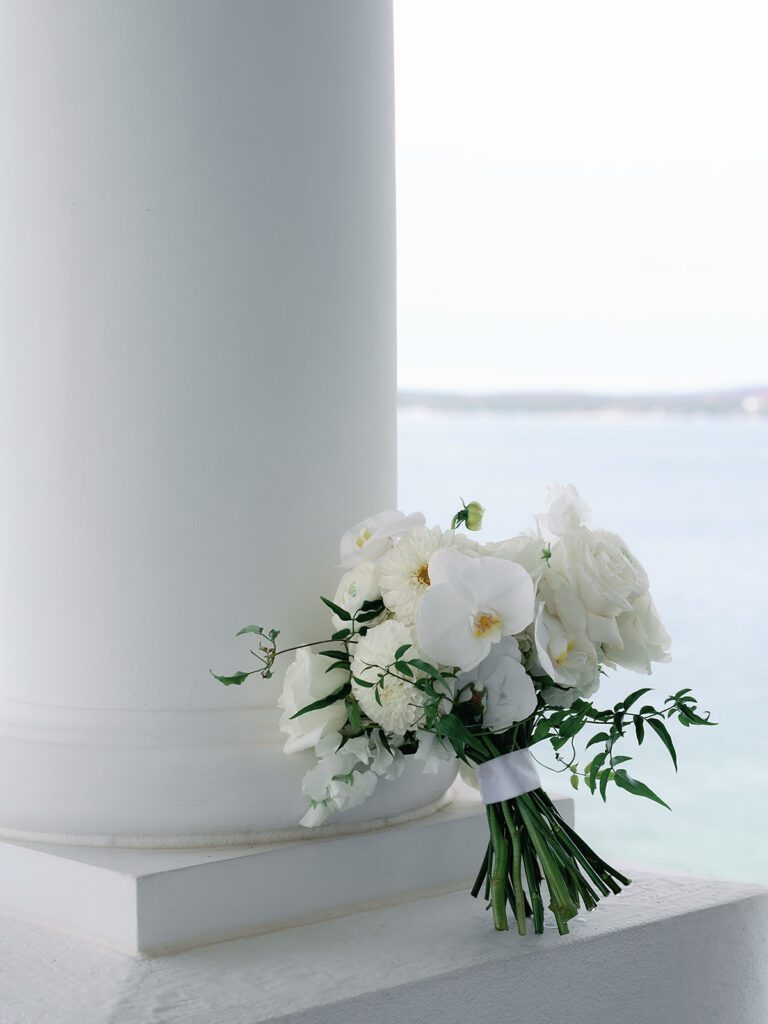 Romantic white florals by Sweetwater Floral posed with Little Traverse Bay in the background