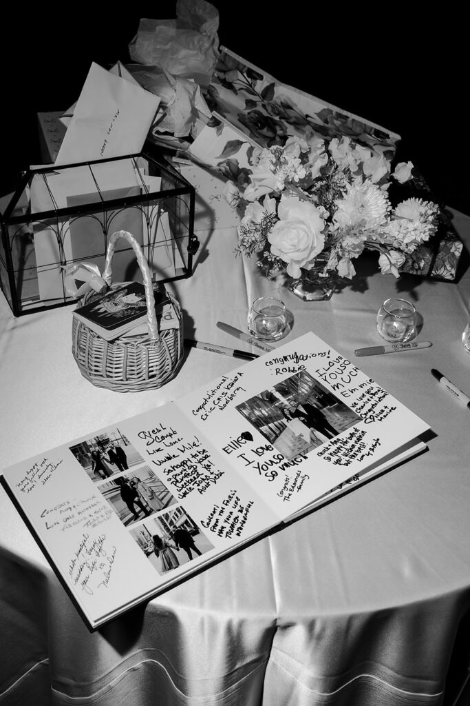 Wedding guest book surrounded by florals, cards, and candles on a table at the Bay Harbor Yacht Club reception.