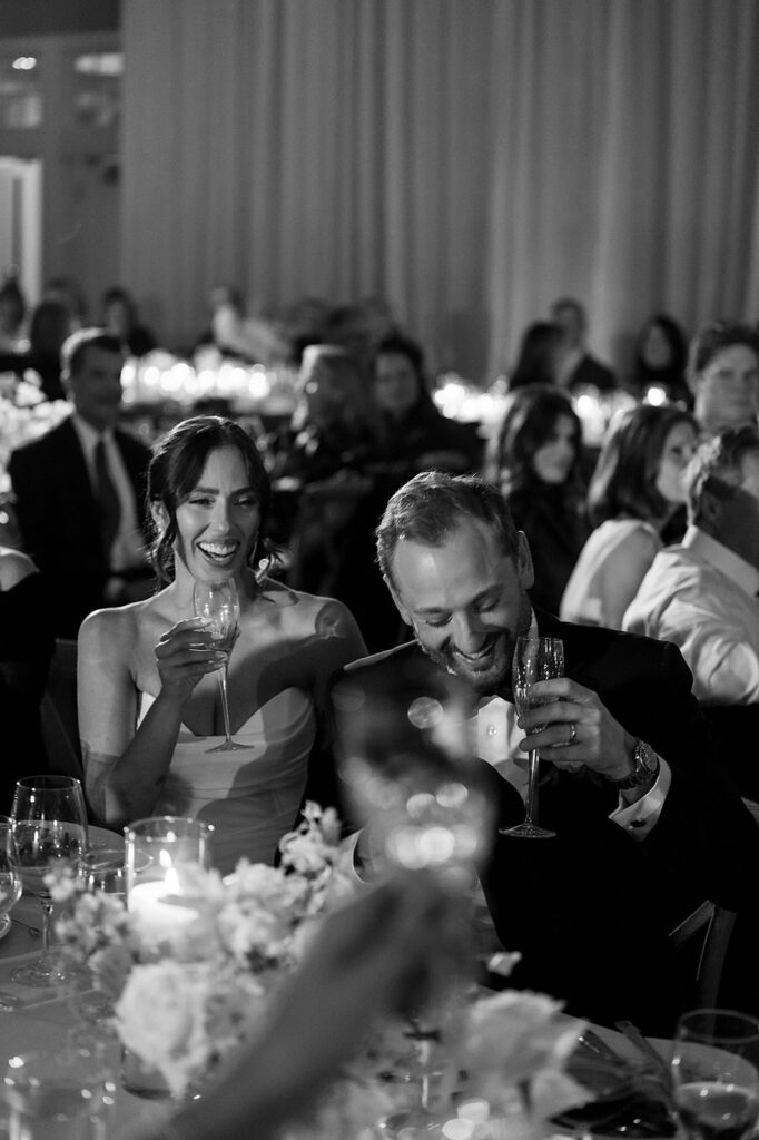 Black and white photo of the bride and groom sharing a toast during their Northern Michigan wedding reception.