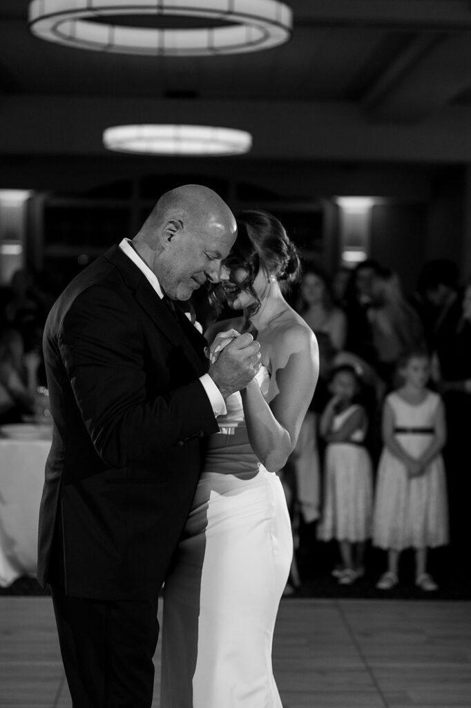 Black and white photo of the bride dancing with her father