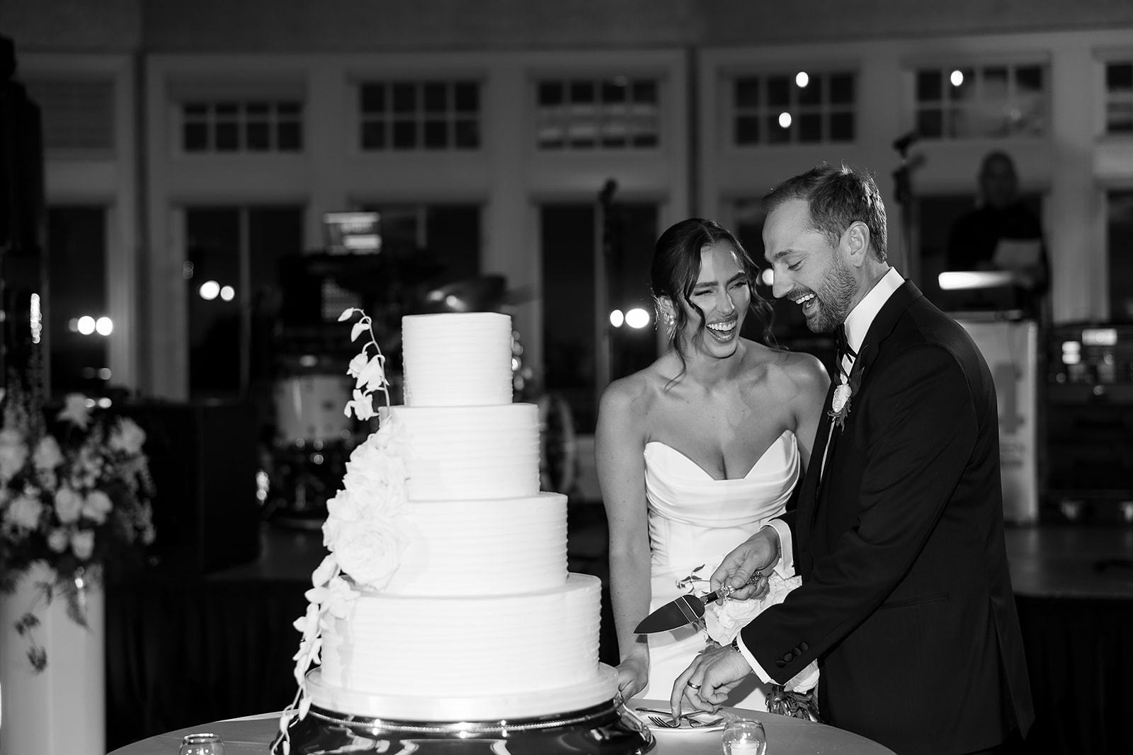 Bride and groom cutting their tiered white wedding cake together during their Bay Harbor Yacht Club wedding reception.