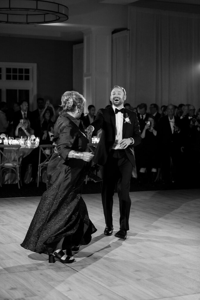 Black and white photo of the groom dancing with his mother