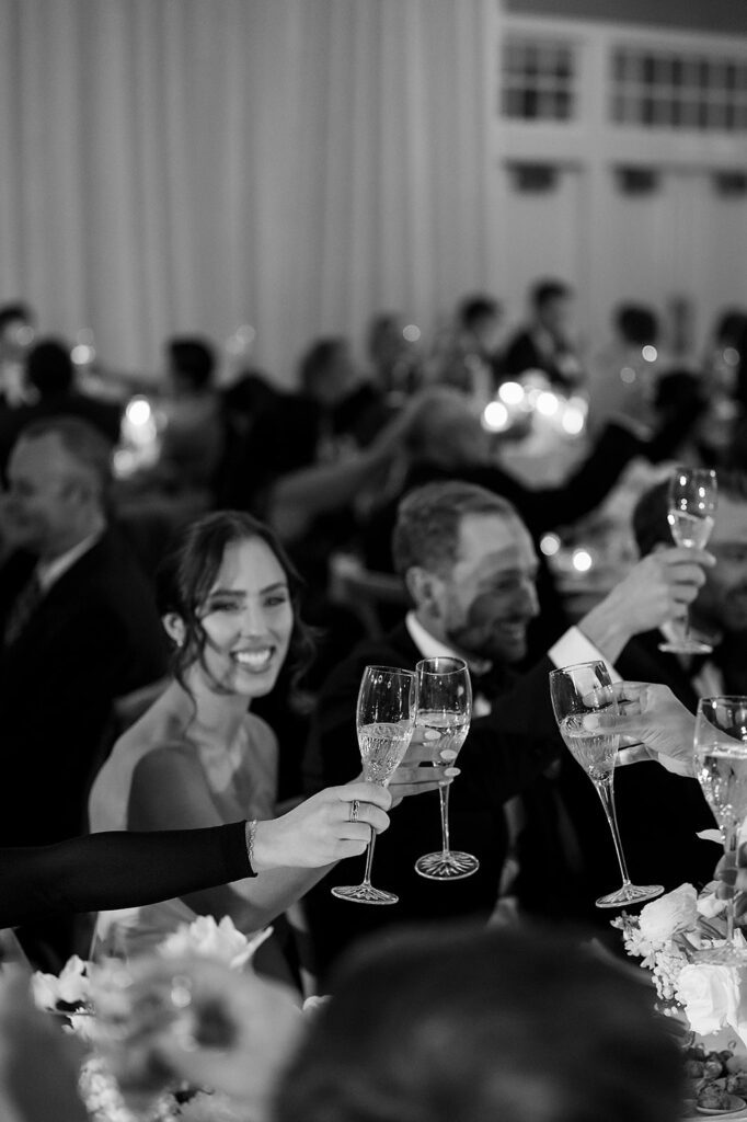Bride and groom toasting with guests during speeches