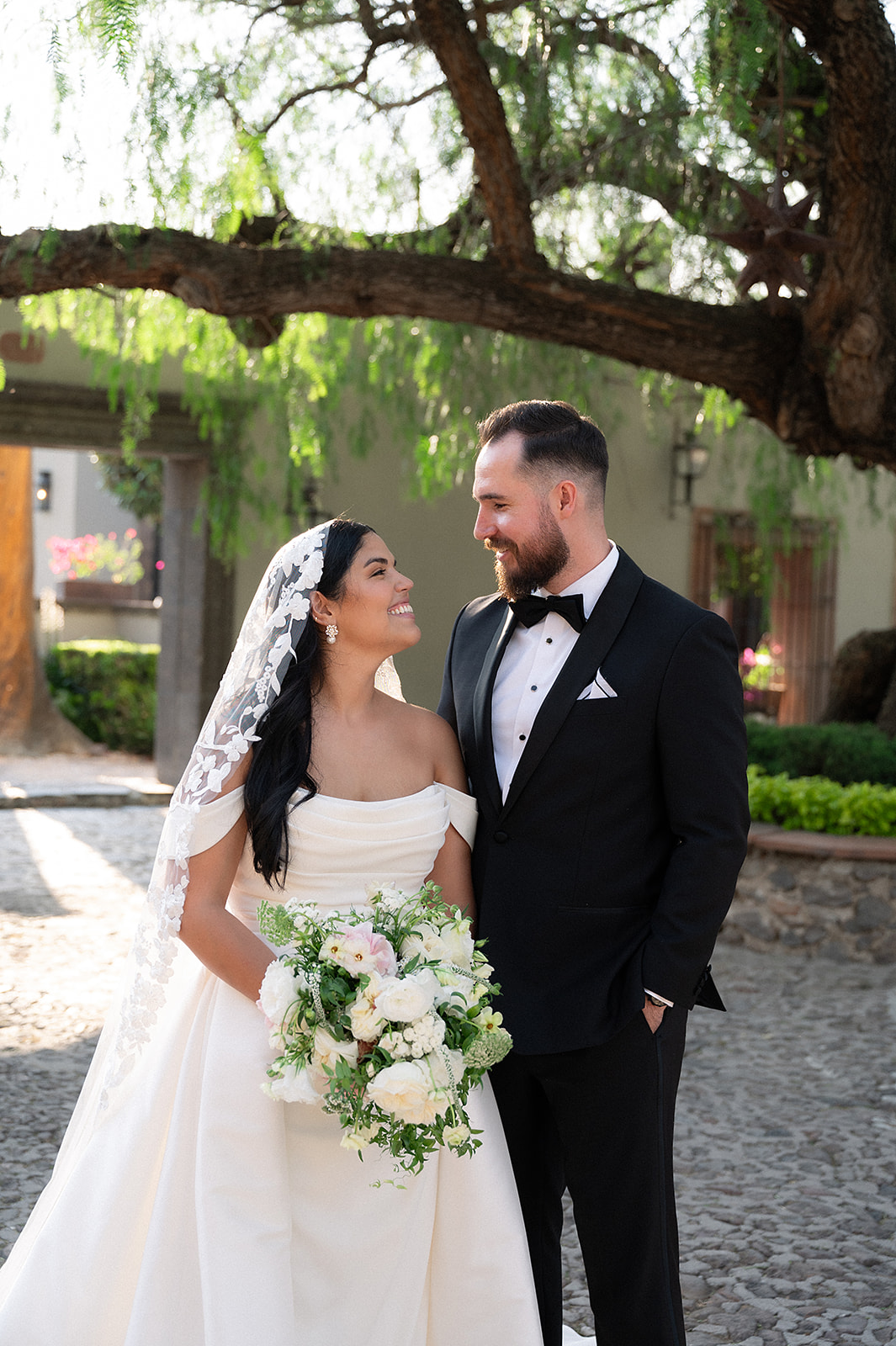 Bride and groom smiling at eachother in the courtyard for their Hacienda San Luis Gonzaga wedding