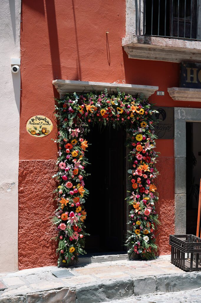 Floral arch at the entrance of La Posadita restaurant in San Miguel de Allende, decorated with colorful flowers for the farewell brunch.