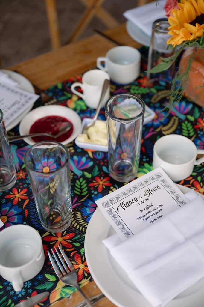 Table setting at La Posadita featuring Otomi-style runner, white plates, and a personalized menu for a farewell brunch.