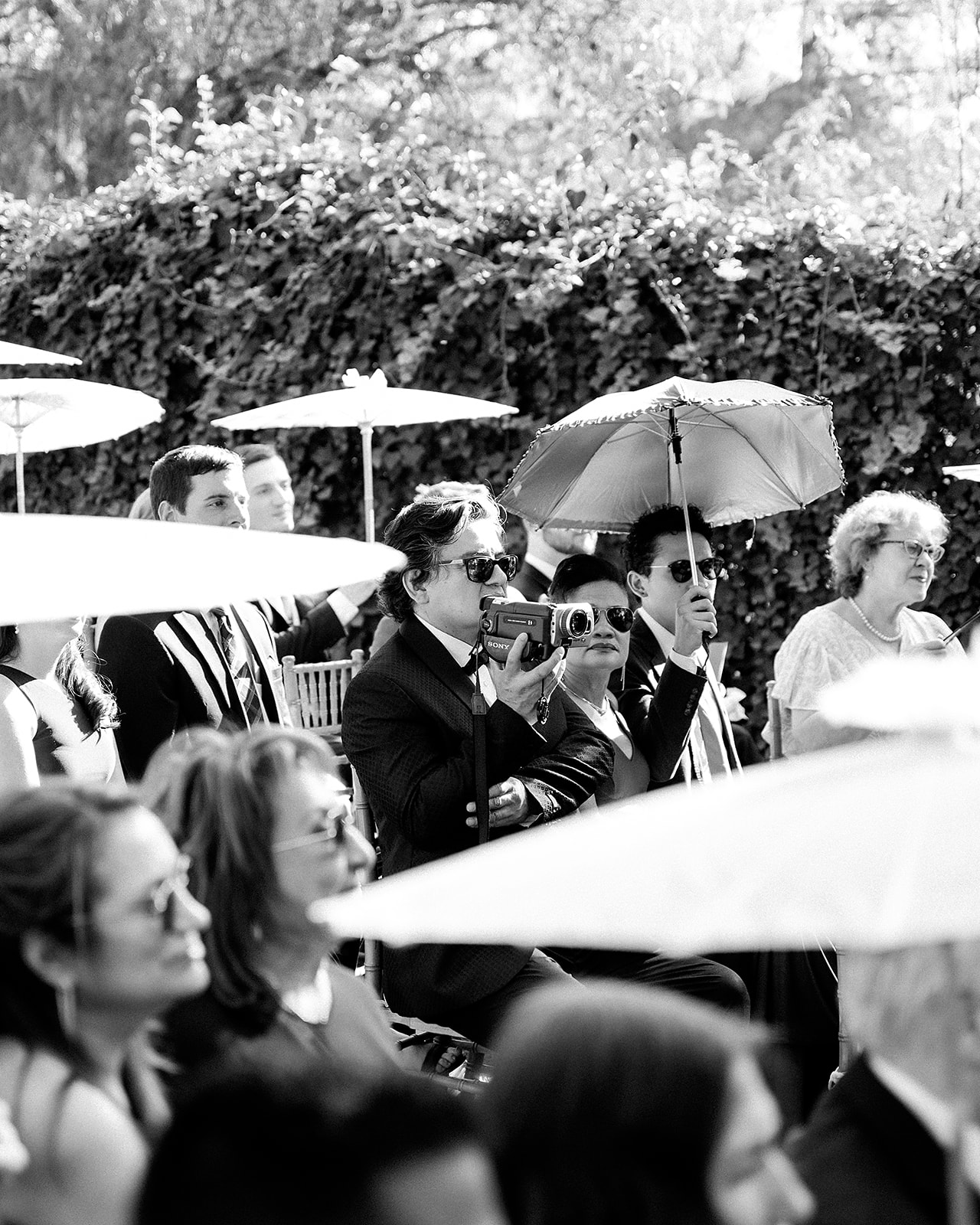 Wedding guest filming the ceremony on a vintage camcorder