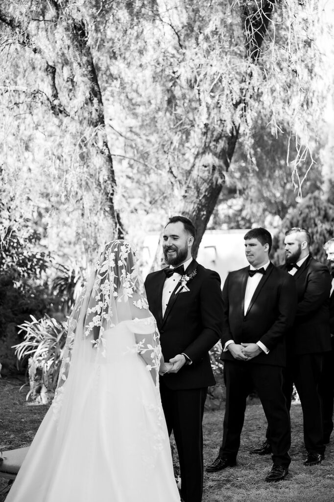 Black and white photo of a bride and groom holding hands at the altar during their San Miguel de Allende wedding ceremony at Hacienda San Luis Gonzaga