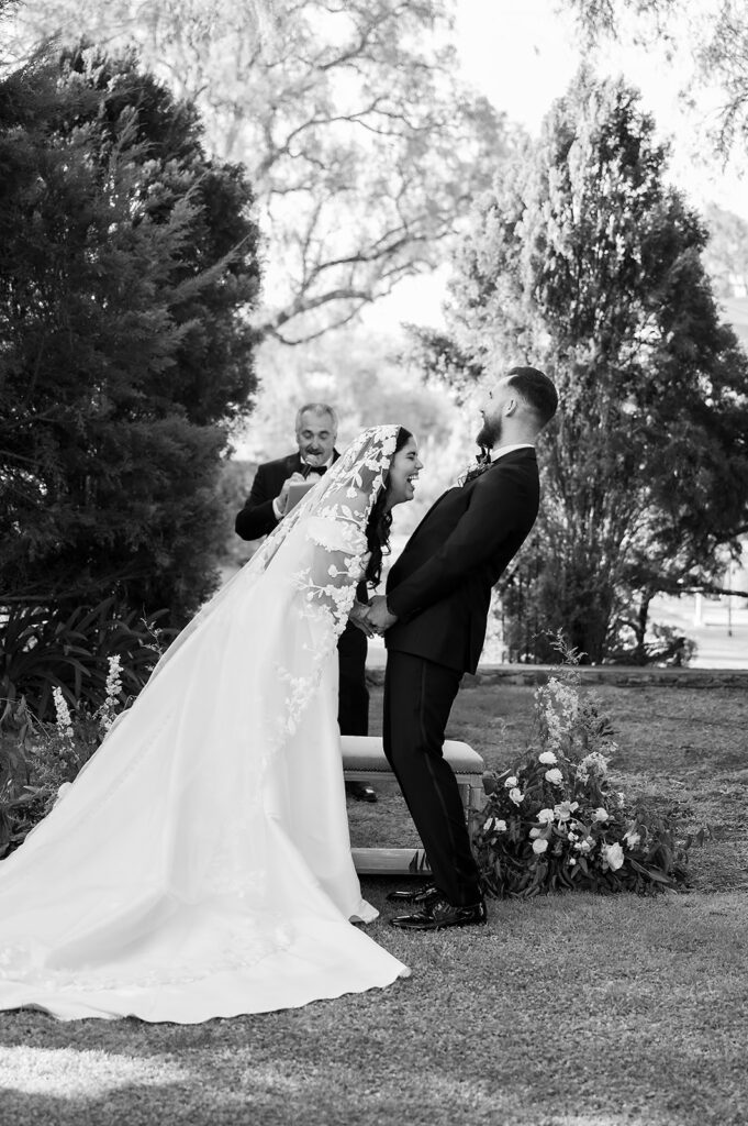 Black and white candid photo of a bride and groom laughing during their San Miguel de Allende wedding ceremony at Hacienda San Luis Gonzaga 