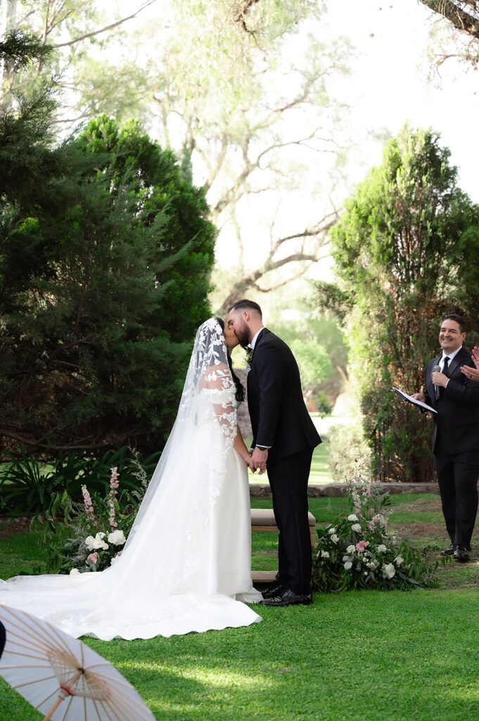 Bride and groom sharing first kiss during ceremony at Hacienda San Luis Gonzaga