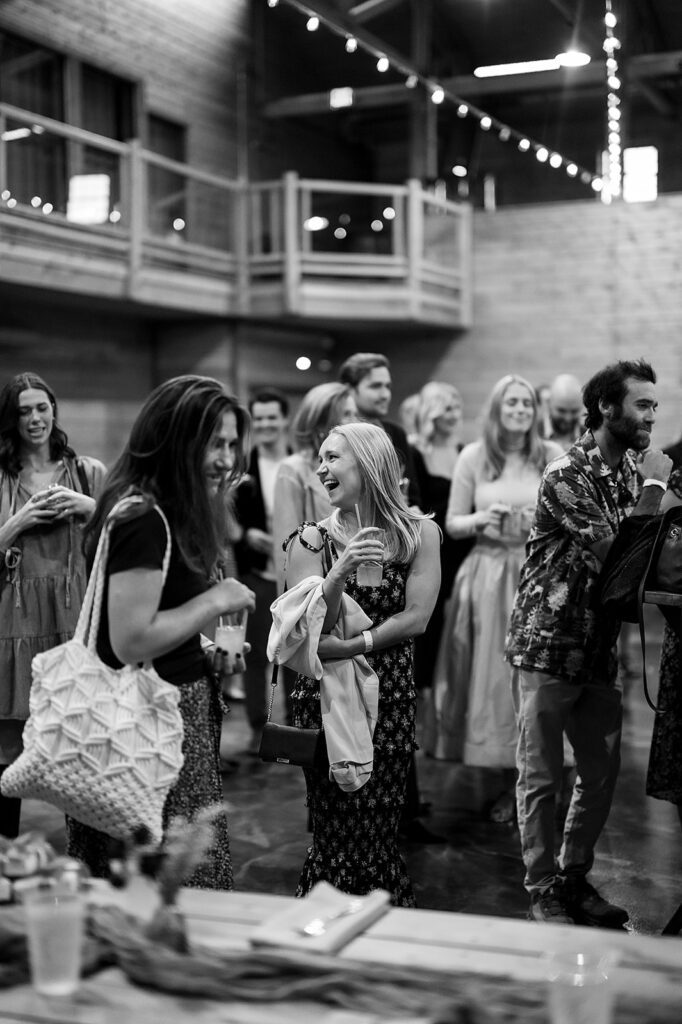 Black and white candid photo of guests mingling during a welcome wedding party
