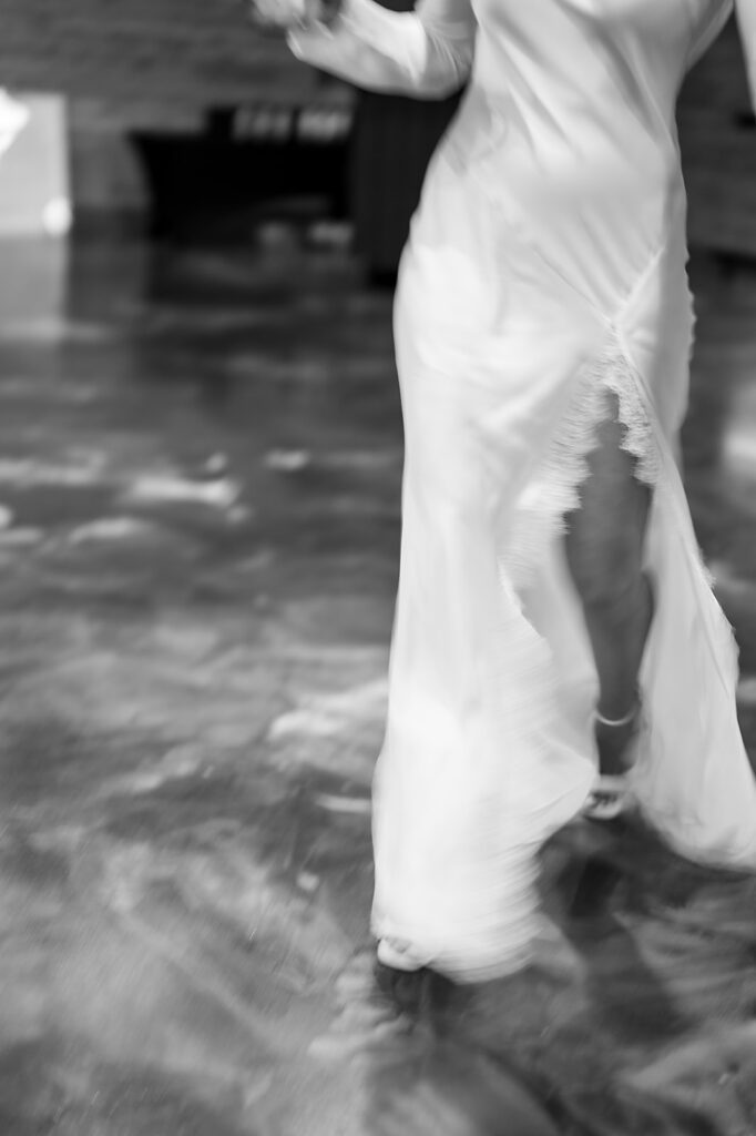 Black and white motion photo of a bride walking