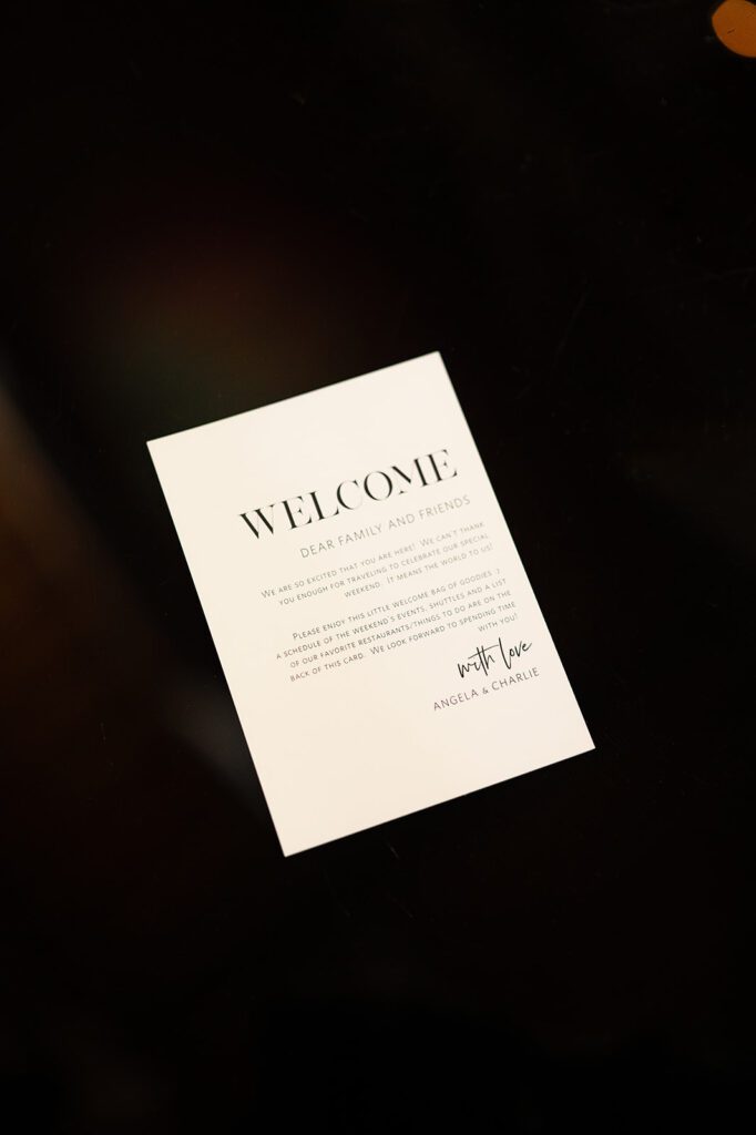 Minimalist black-and-white welcome card from Angela and Charlie thanking guests for joining their Bay Harbor wedding weekend.