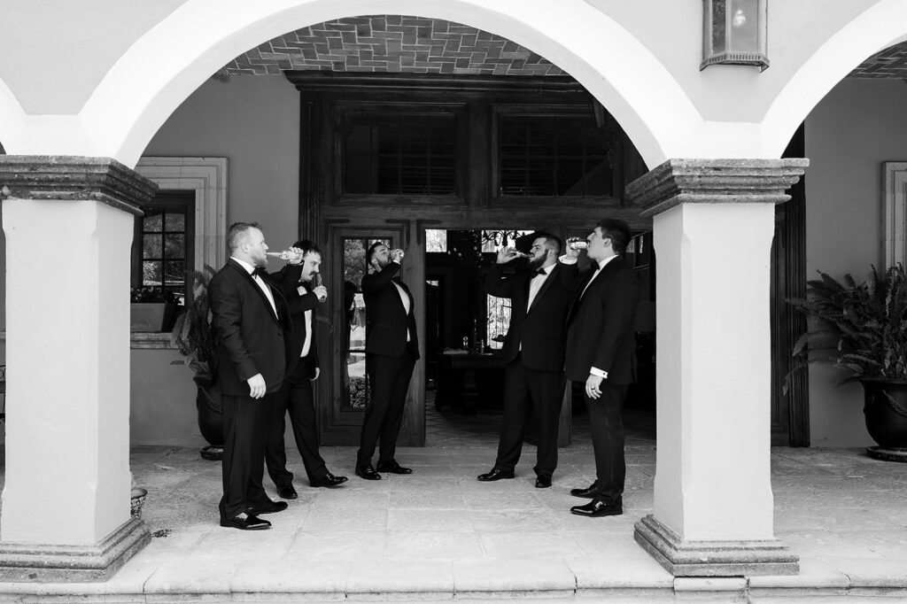 Groomsmen having drinks under arches at Hacienda San Luis Gonzaga before San Miguel de Allende wedding