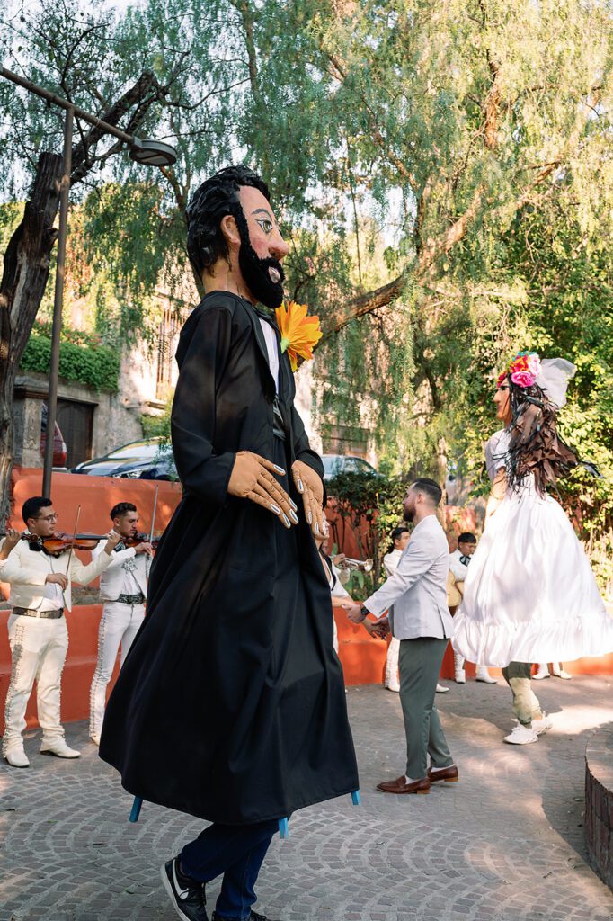 Traditional giant puppets, known as mojigangas, dance during the lively callejoneada parade in San Miguel de Allende.