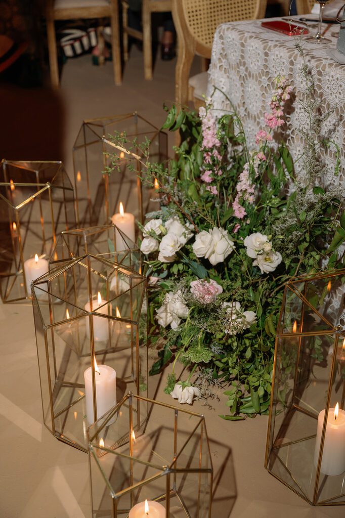 Close-up of gold geometric lanterns and white floral arrangements surrounding the sweetheart table at Hacienda San Luis Gonzaga reception.