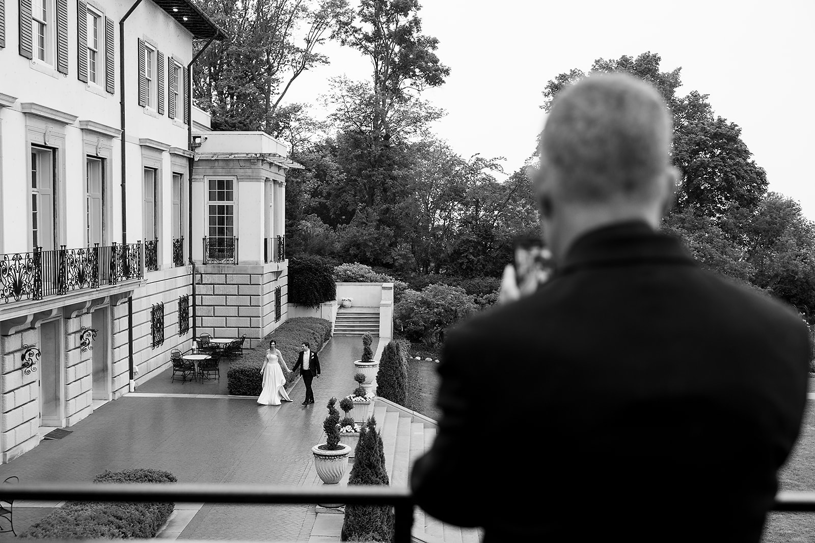 Bride and groom walking hand in hand outside Grosse Pointe War Memorial for their first dance before their reception.