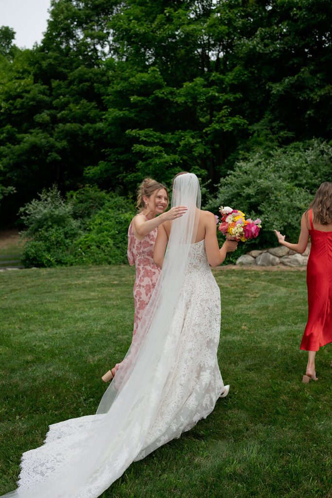 Candid photo of a bride walking with her bridesmaids outdoors.