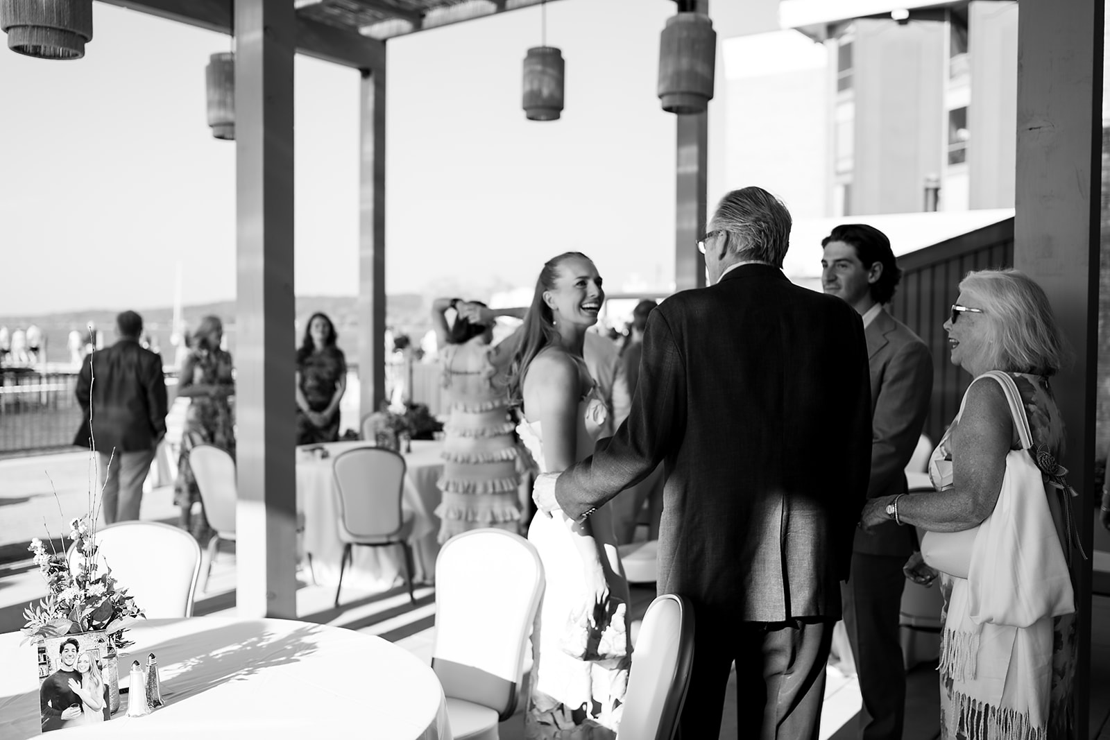 Black and white photo of guests socializing at a Delamar Traverse City wedding welcome party.