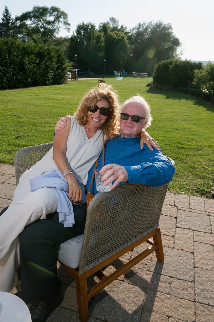 Guests relaxing and chatting outdoors at Delamar with scenic Northern Michigan lake views in the background.