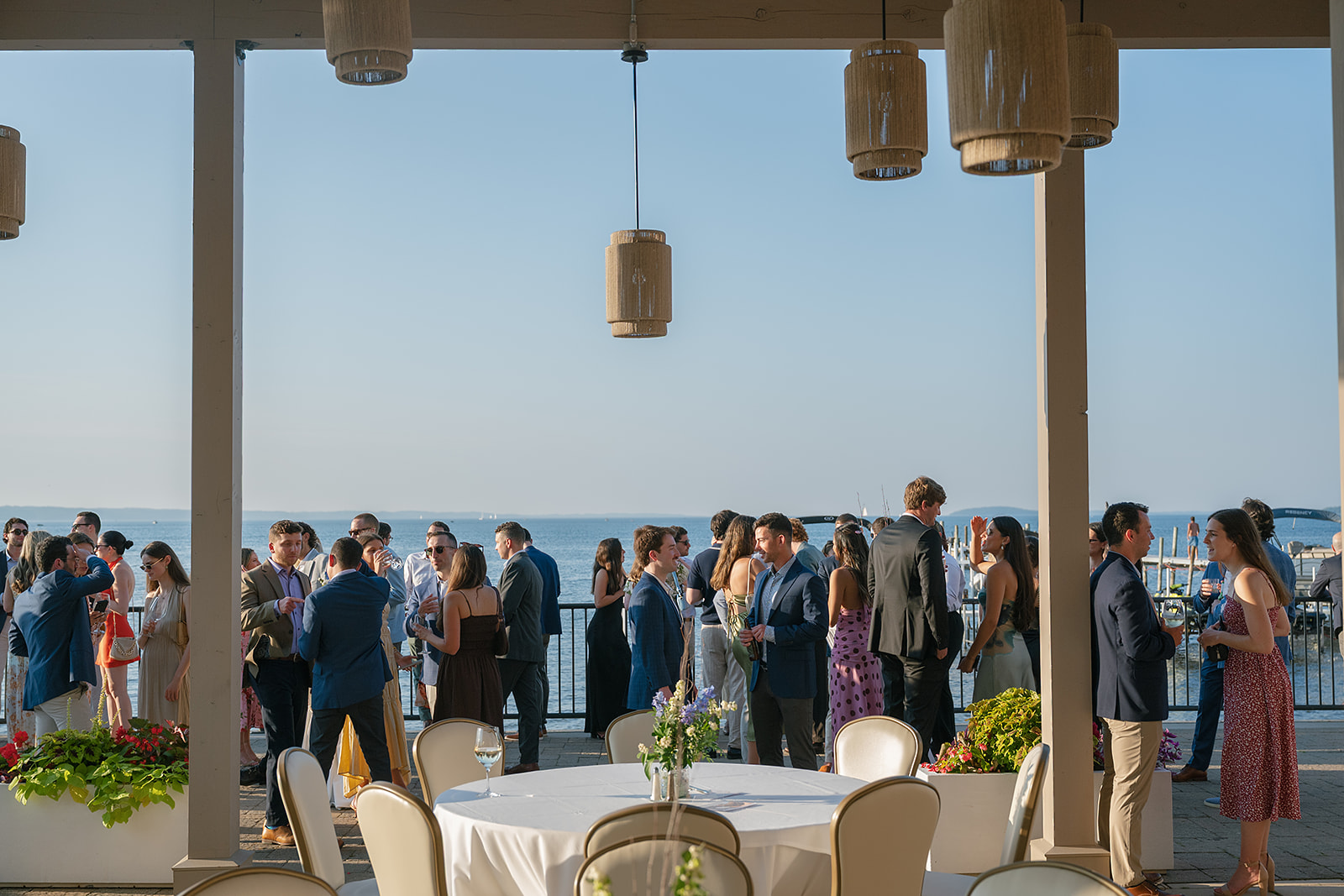 Candid moment of wedding guests gathering on the Delamar patio with lake views in Traverse City, Michigan.