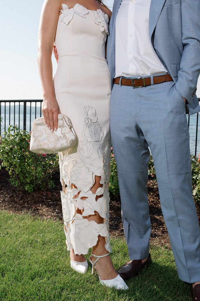 Close up shot of the couples welcome wedding party outfits by the water.