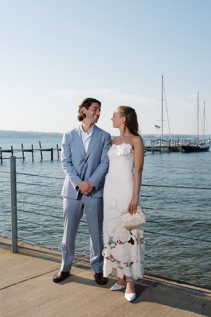Couple sharing a quiet moment by the water at their Delamar Traverse City wedding welcome party.