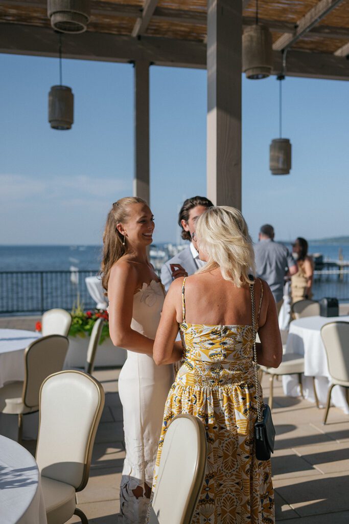 Guests mingling on the Delamar terrace overlooking Grand Traverse Bay during a Northern Michigan wedding weekend.