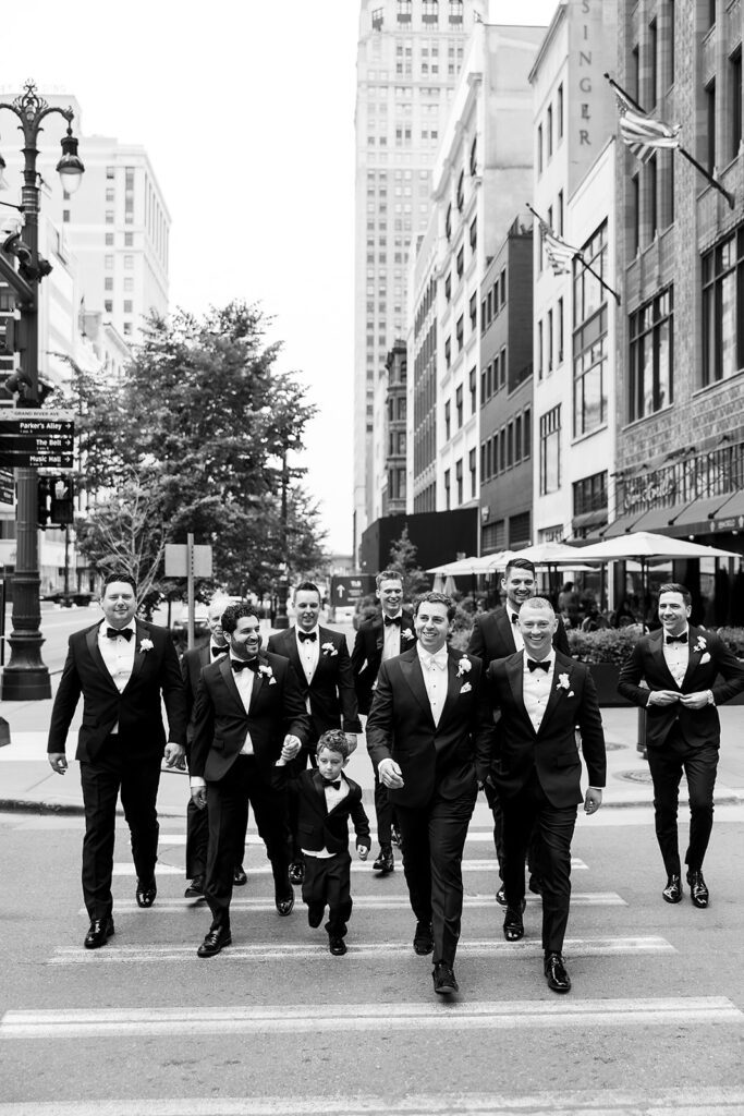 Groom and groomsmen walking through downtown Detroit for classic wedding portraits.