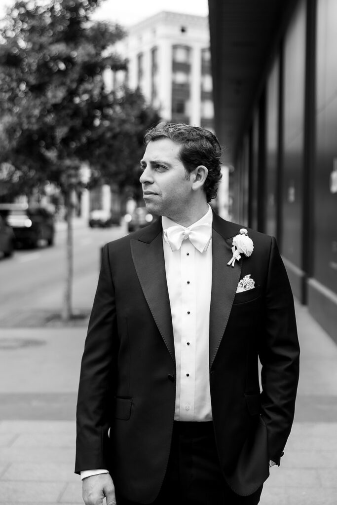 Groom standing on a downtown Detroit sidewalk during wedding portraits before the ceremony.