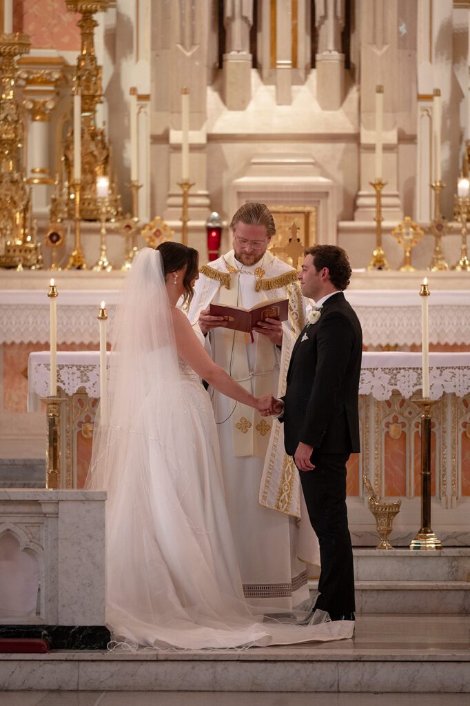 Priest officiating a wedding ceremony inside Sweetest Heart of Mary Church in Detroit.