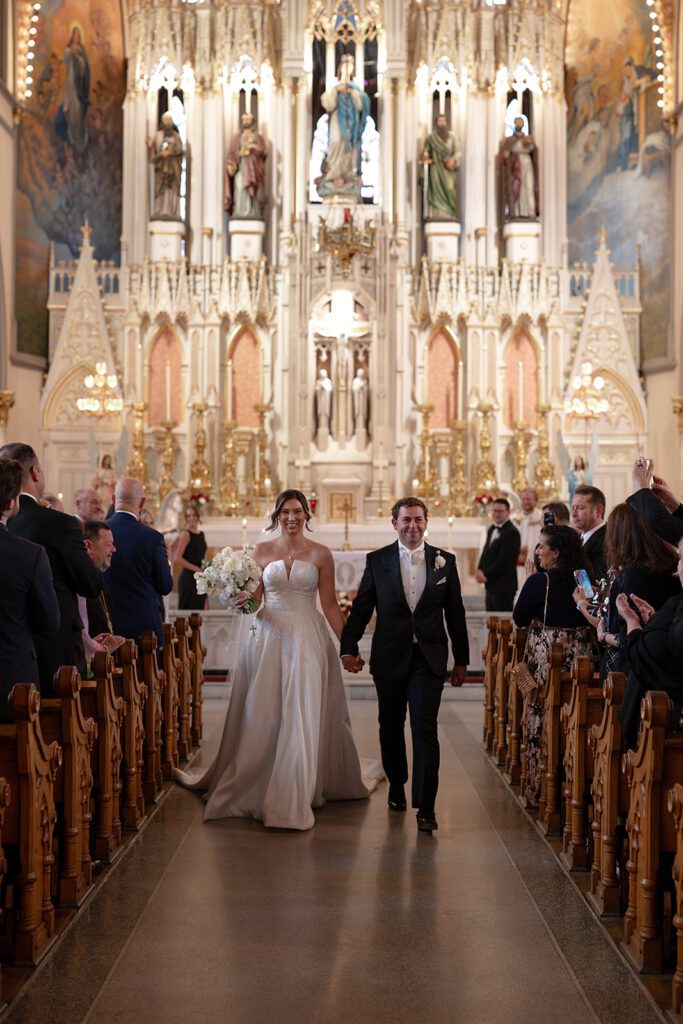 Bride and groom walking back down the aisle after their Sweetest Heart of Mary wedding ceremony in Detroit.