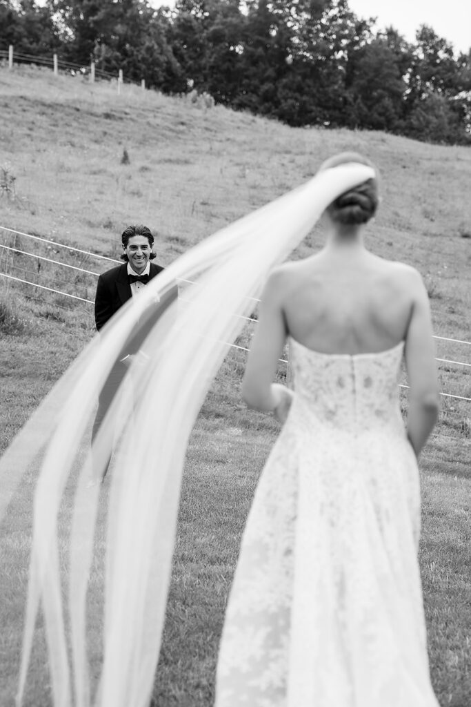 Bride approaches groom during their first look at Noverr Farms in Traverse City, Michigan.
