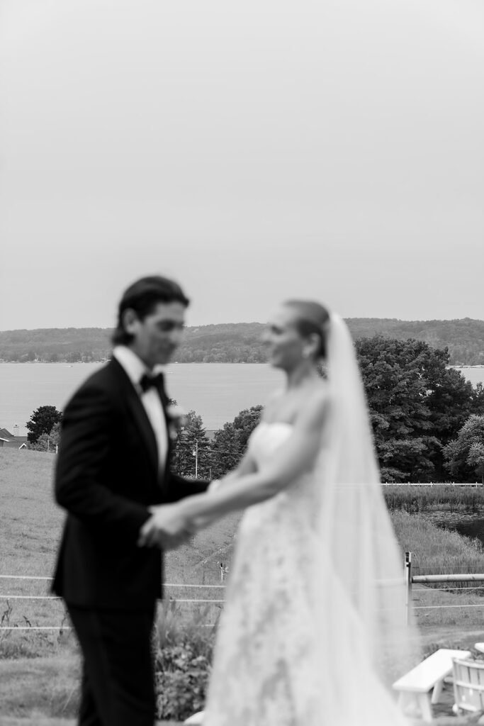 Black and white photo of a bride and groom holding hands at Noverr Farms in Traverse City, Michigan.