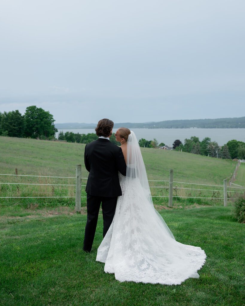 Bride and groom admiring the views of Lake Leelanau at Noverr Farms in Traverse City, Michigan.