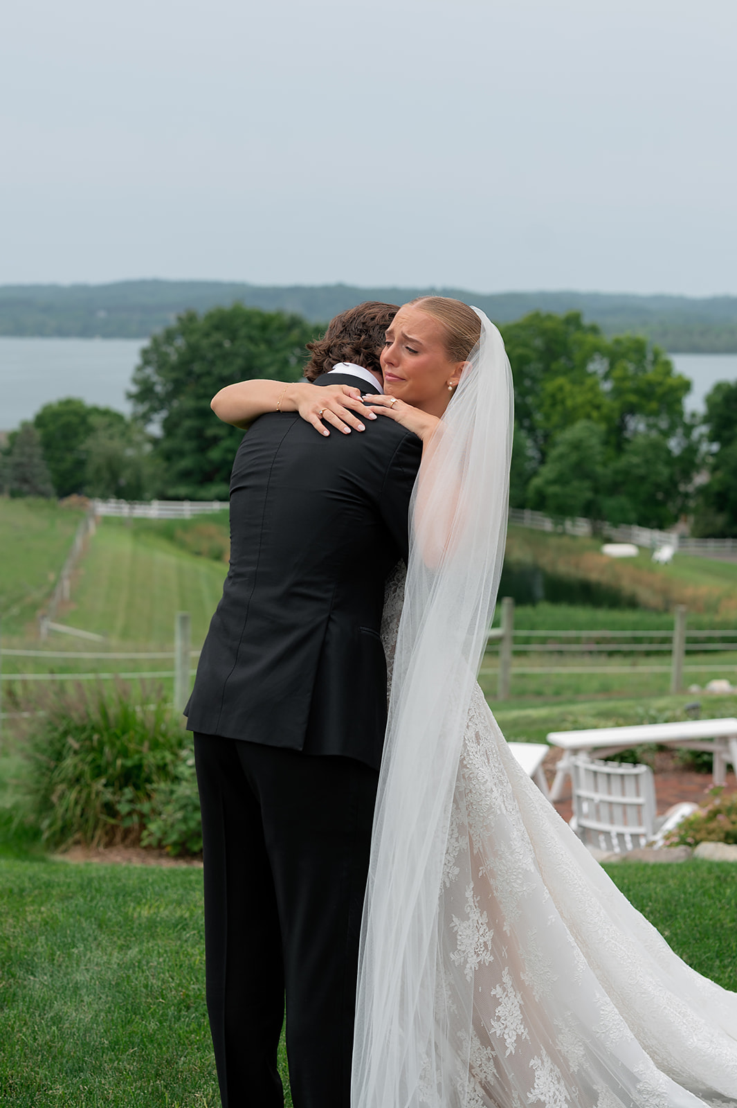 Bride and groom share a quiet moment after their first look at Noverr Farms with sweeping Lake Leelanau views.