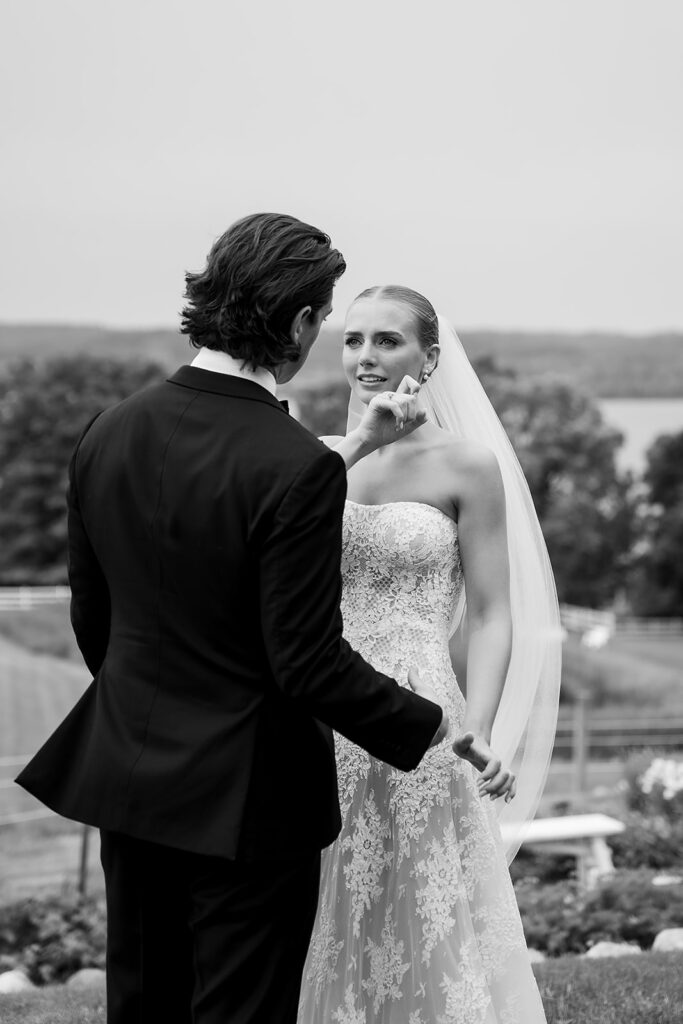 Bride wiping away a tear as her and the groom share an emotional first look at Noverr Farms in Traverse City, Michigan.