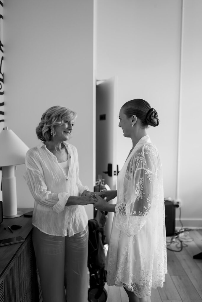 Bride holding hands with a loved one during an emotional getting ready moment.