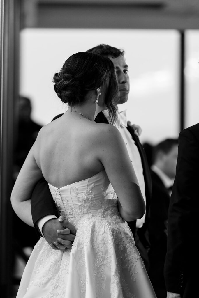 Black and white photo of a bride and groom standing during speeches.