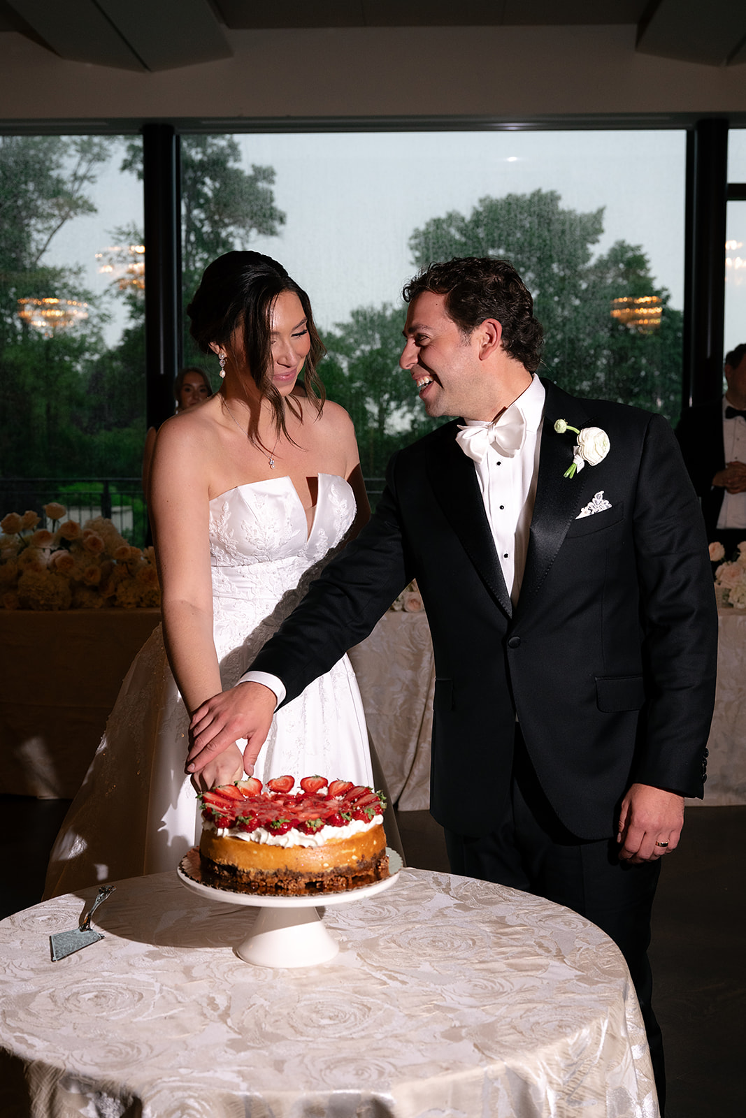 Flash photo of the bride and groom cutting their cake during their ballroom wedding reception