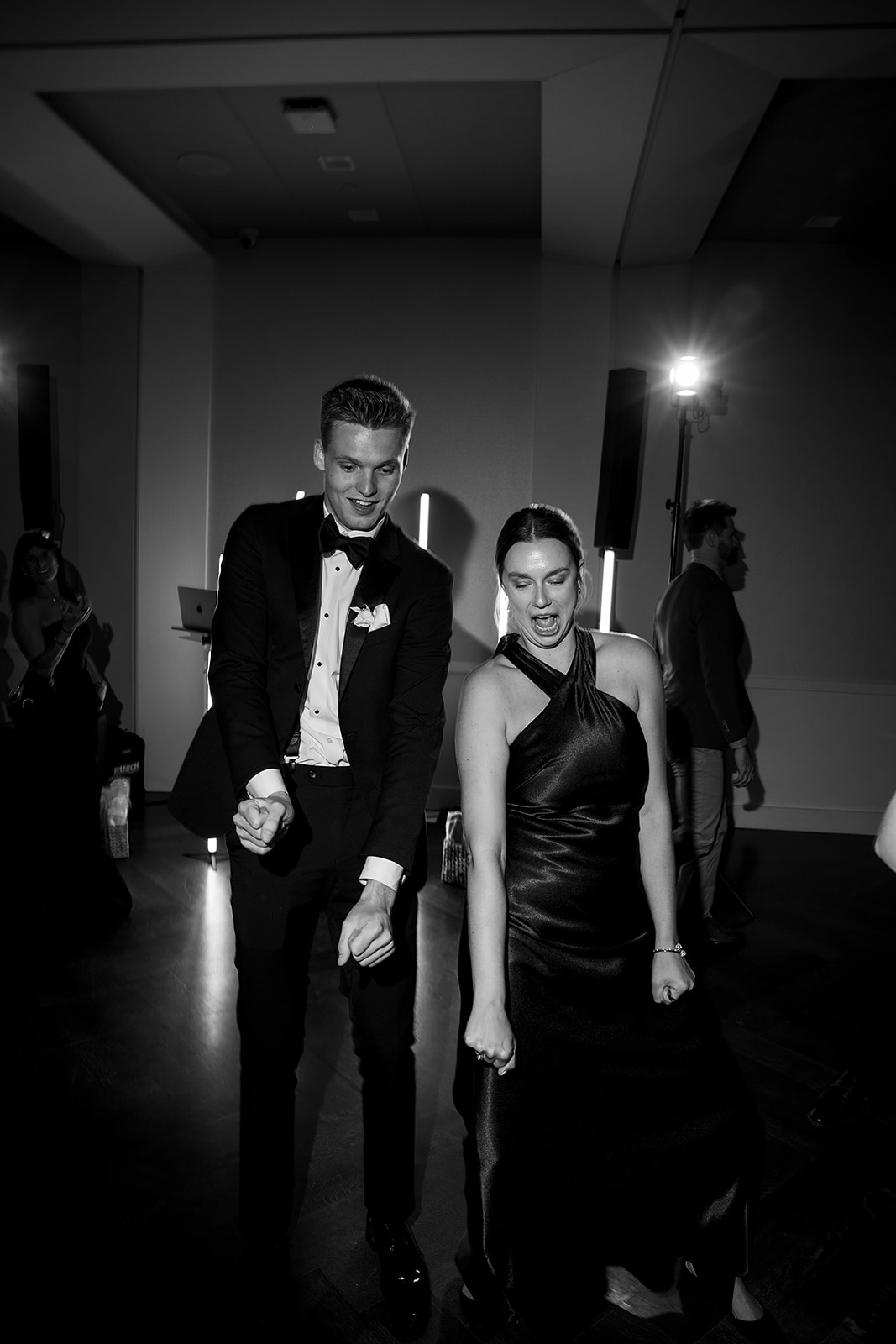 Black and white photo of guests dancing during the reception.