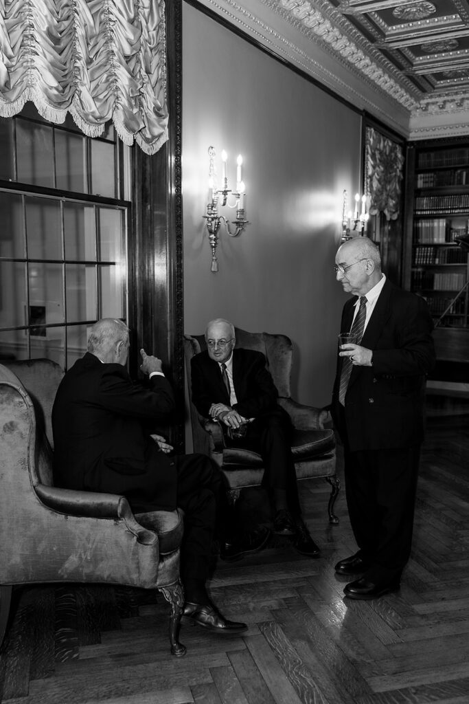 Black and white photo of guests mingling during a Grosse Pointe War Memorial wedding cocktail hour.
