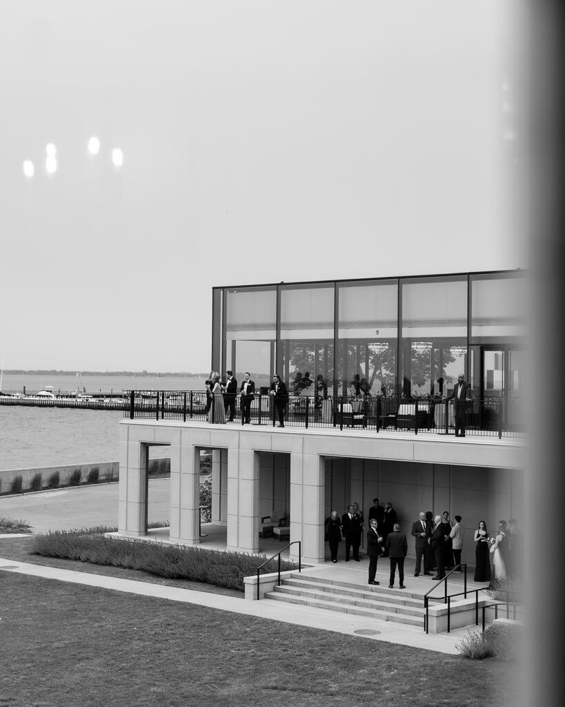Guests mingling during cocktail hour on the patio at a Grosse Pointe War Memorial wedding.
