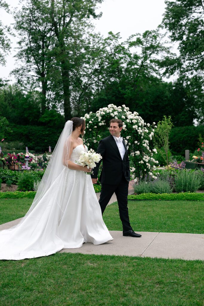 Bride and groom walking along a pathway at The War Memorial in Grosse Pointe Farms in Michigan.