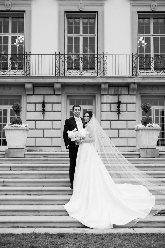 Black and white wedding portrait of a bride and groom on the steps of The War Memorial in Grosse Pointe Farms.