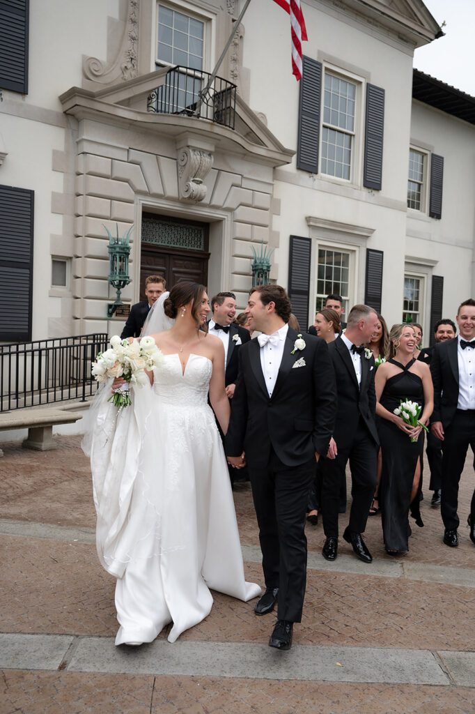 Couple walking with their wedding party outside The War Memorial wedding venue.