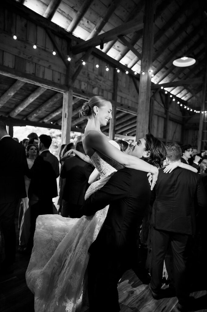 Bride being lifted by the groom during the wedding reception at Noverr Farms in Traverse City, Michigan.
