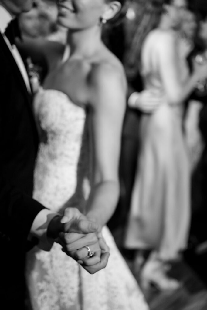 Bride and groom holding hands on the dance floor during their Noverr Farms wedding reception in Traverse City, Michigan.