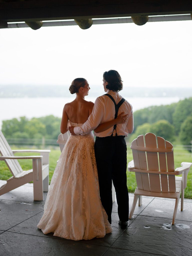 Bride and groom standing together overlooking Lake Leelanau during their Noverr Farms wedding in Traverse City, Michigan.